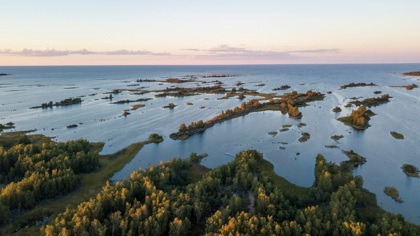 Kouvola — green grass and trees near body of water during daytime