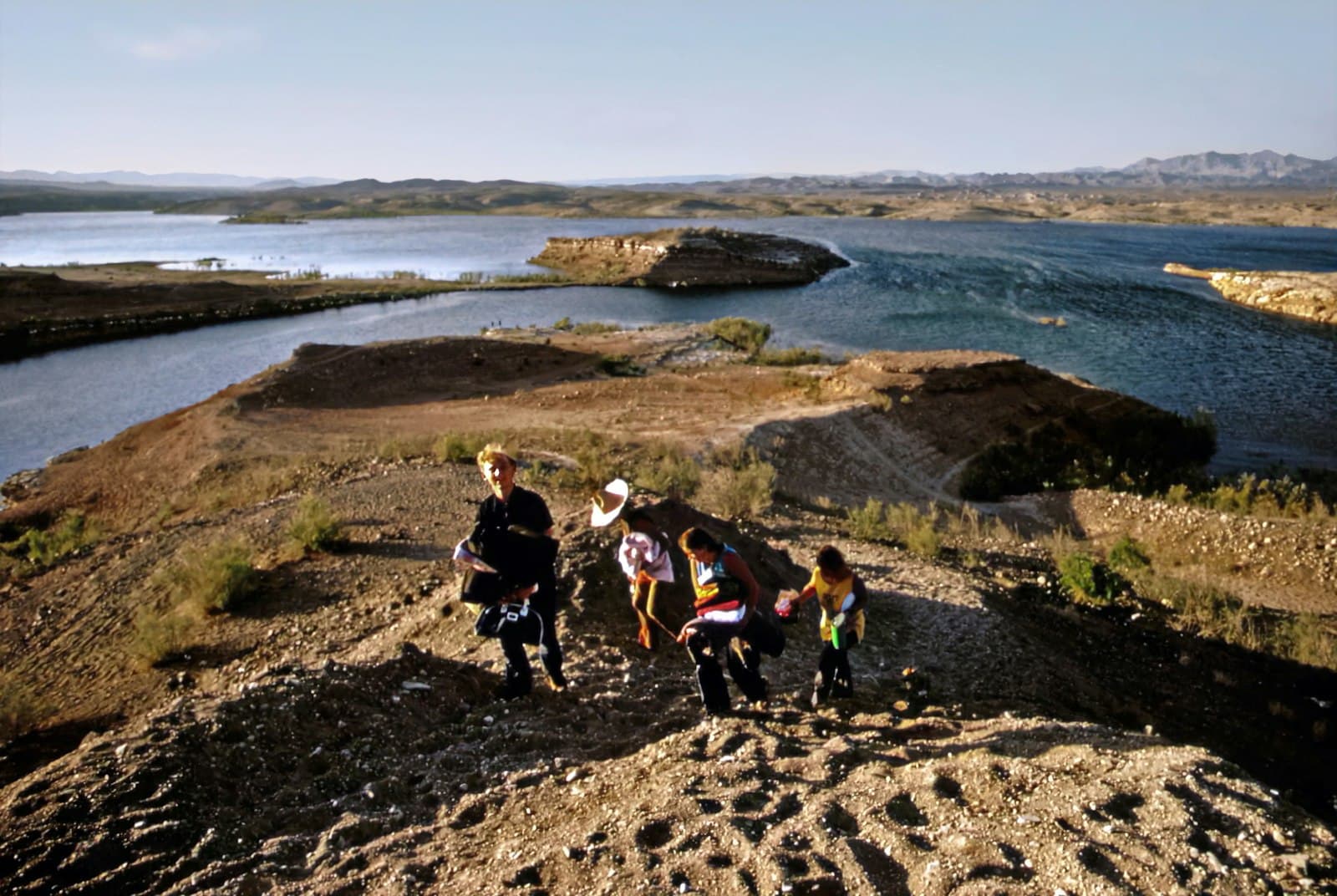 Lake Charles — a group of people walking up a hill next to a lake