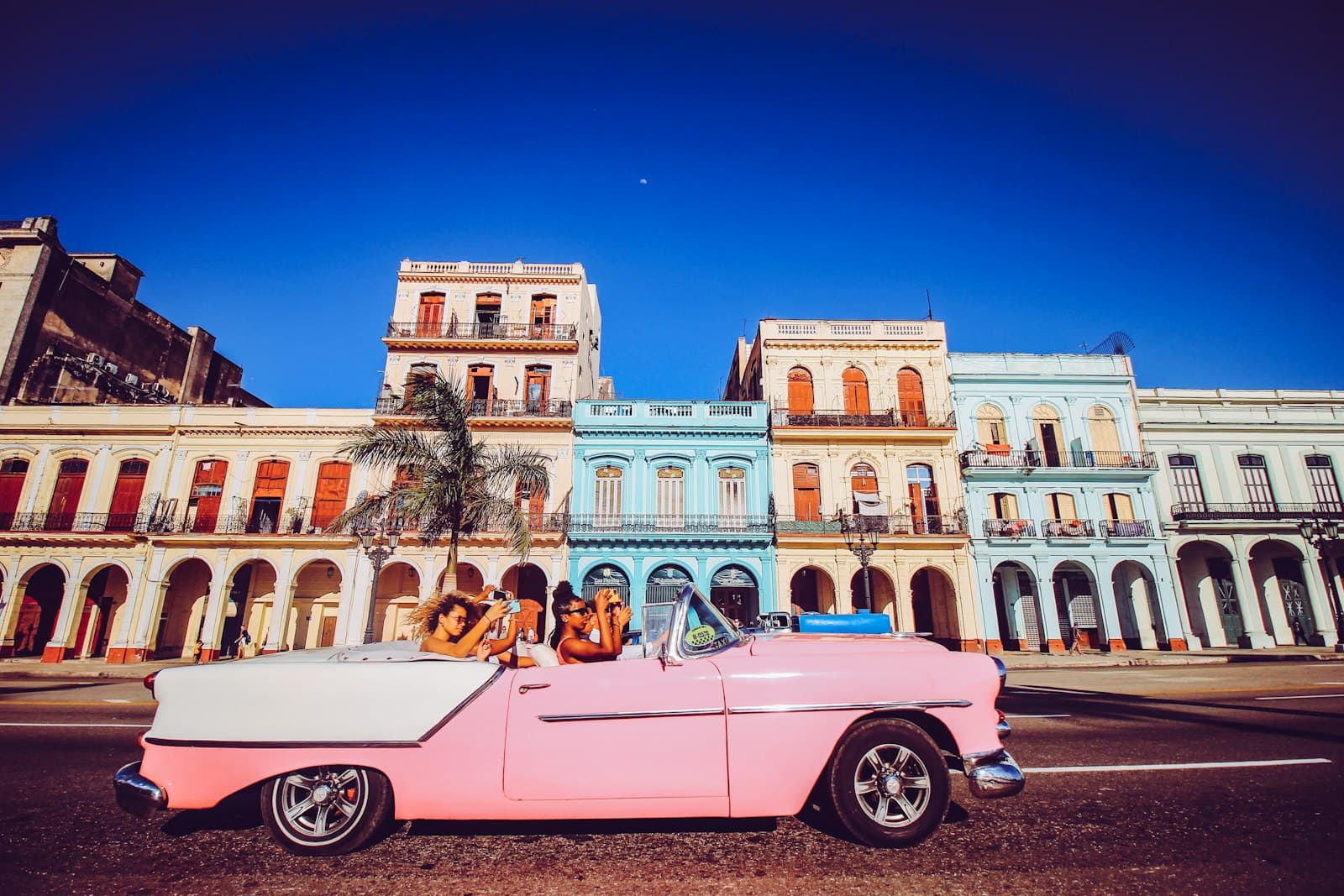 Las Terrazas — pink convertible car parked near beige concrete building during daytime