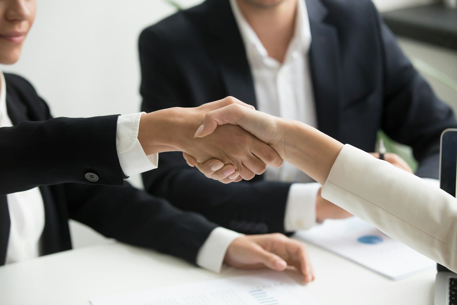 Lewes — two people shaking hands in front of a laptop