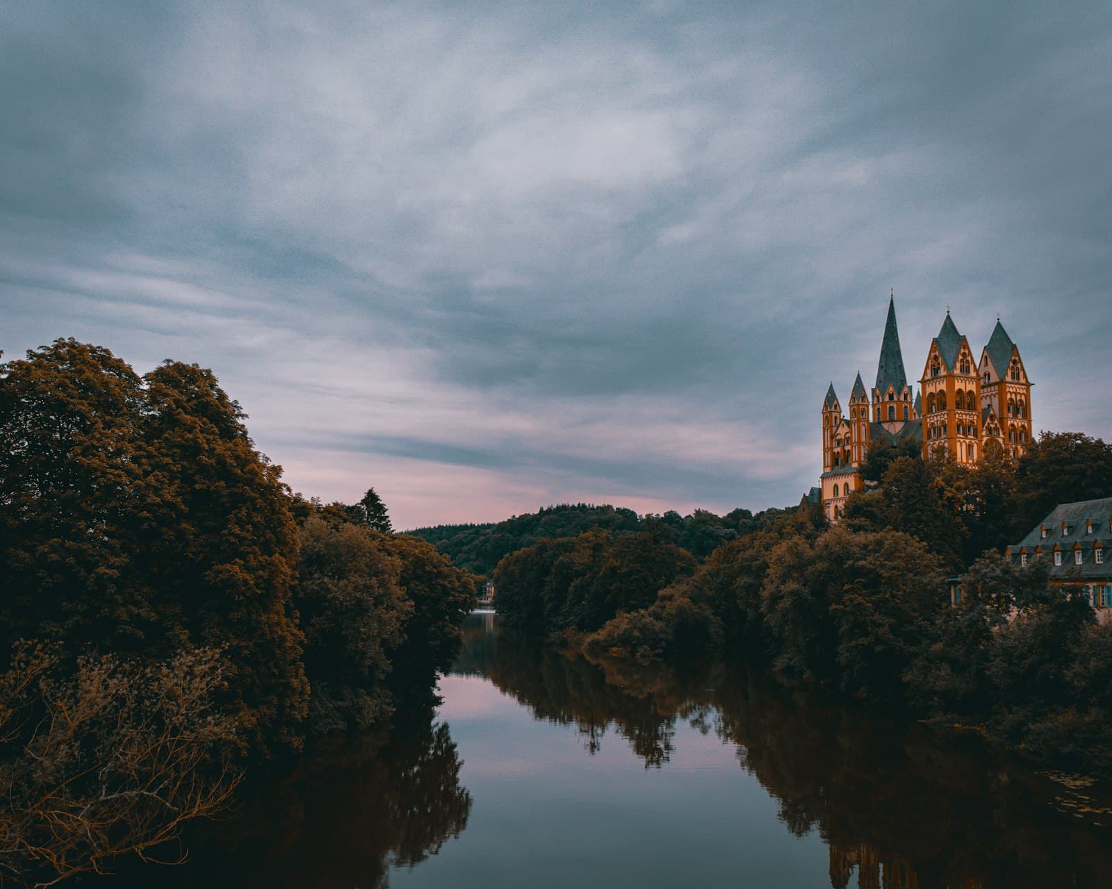 Limburg an der Lahn — brown castle on top of hill near lake under cloudy sky during daytime