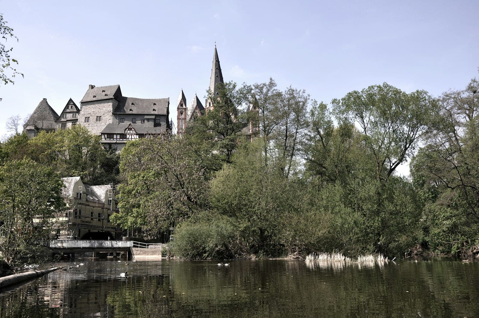 Limburg an der Lahn — brown and gray concrete building near green trees and body of water during daytime