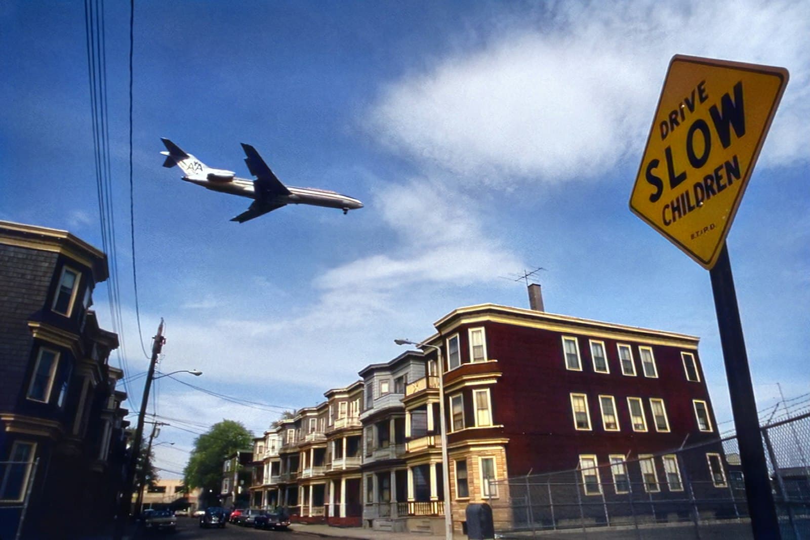 Logan — a plane is flying over a row of houses