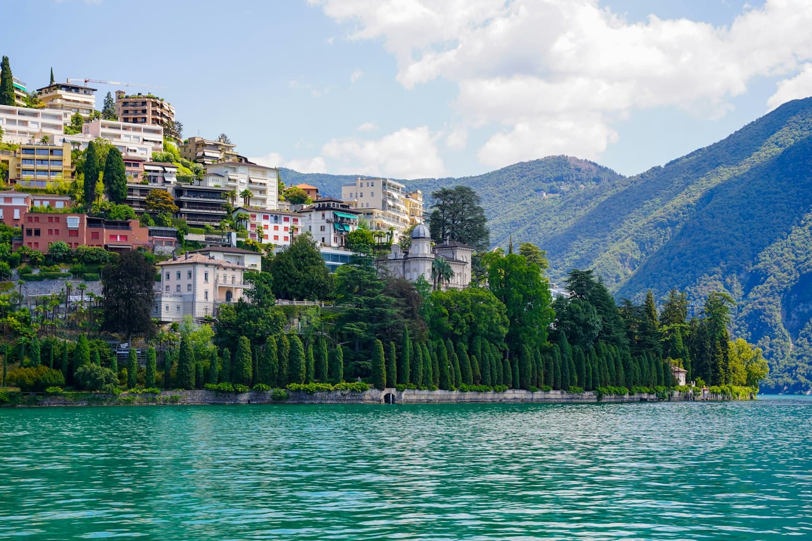 Lugano — a body of water with buildings and trees by it