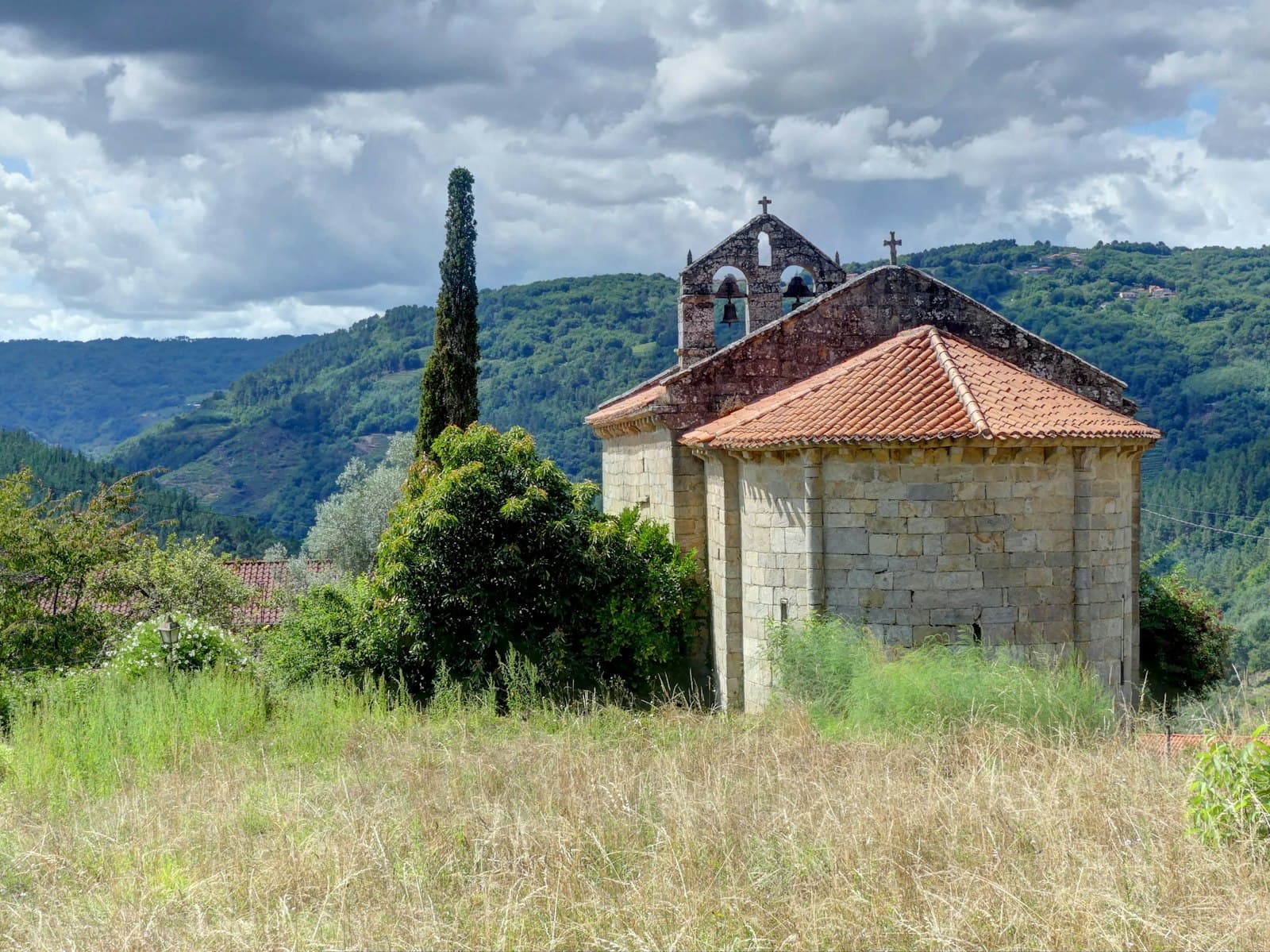 Lugo — brown and white concrete house near green trees and mountain during daytime