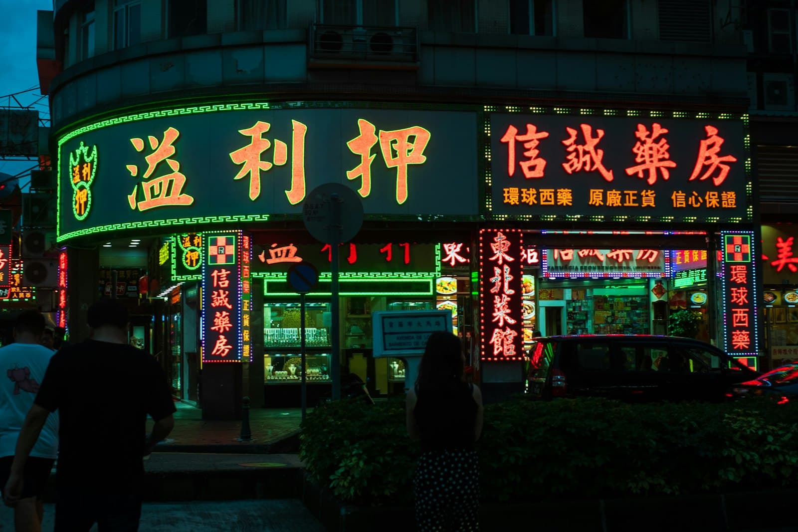 Macao — A group of people walking down a street at night