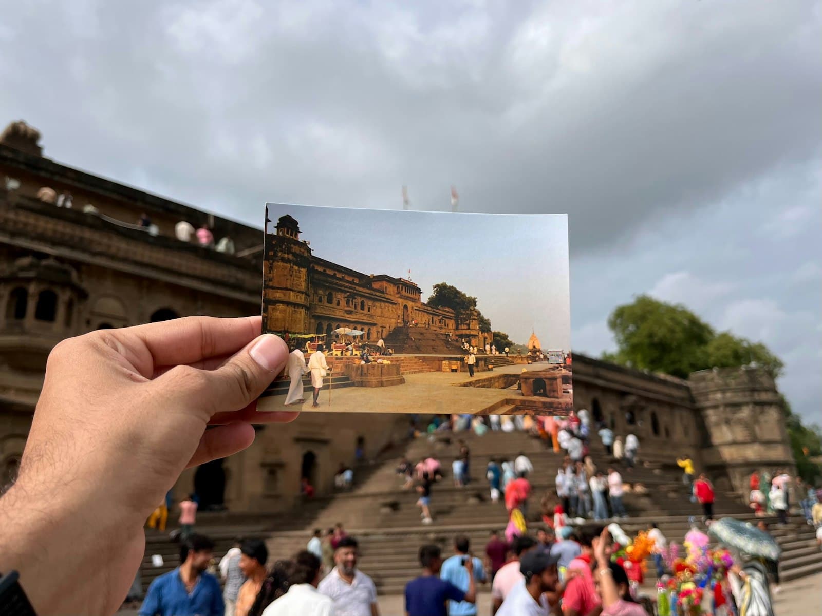 Maheshwar — A person holding up a photo of a crowd of people
