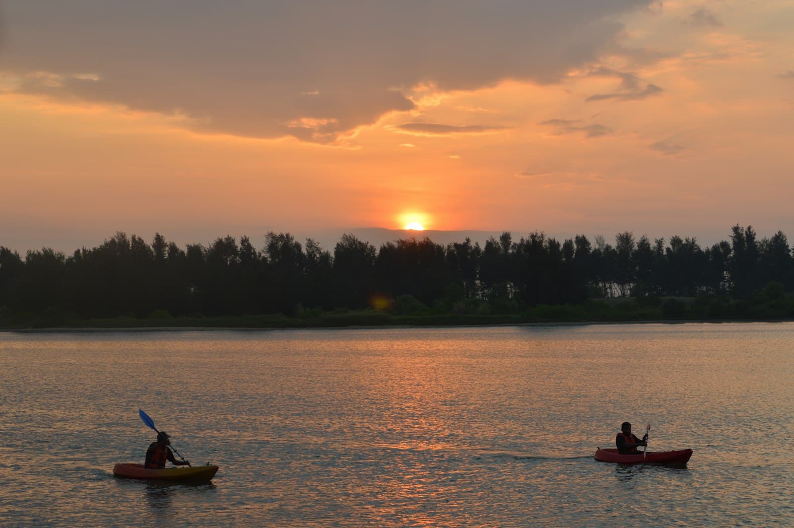 Mangalore — silhouette of 2 people riding on boat during sunset