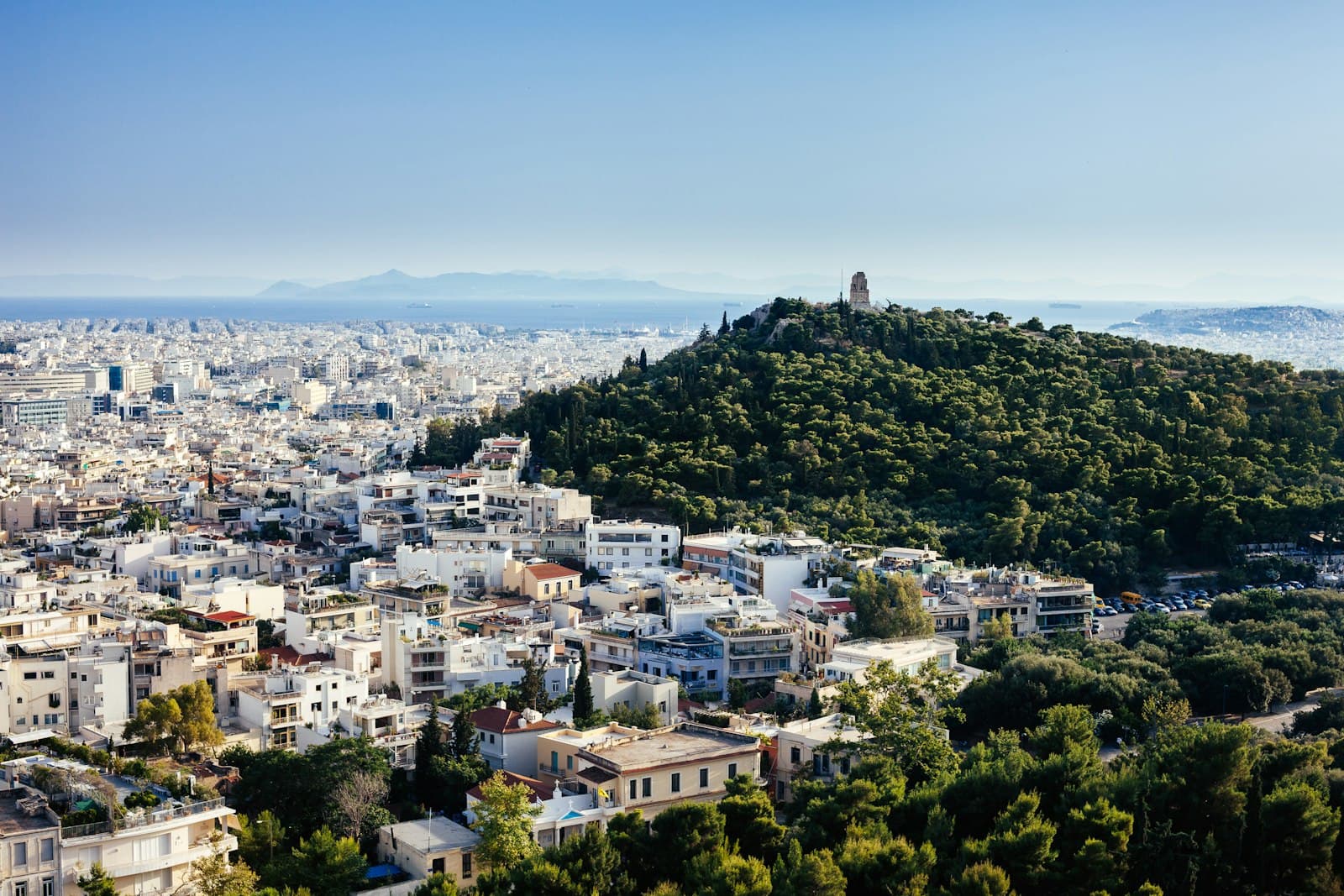 Marathon — aerial view photography of city beside forest under white clouds during daytime