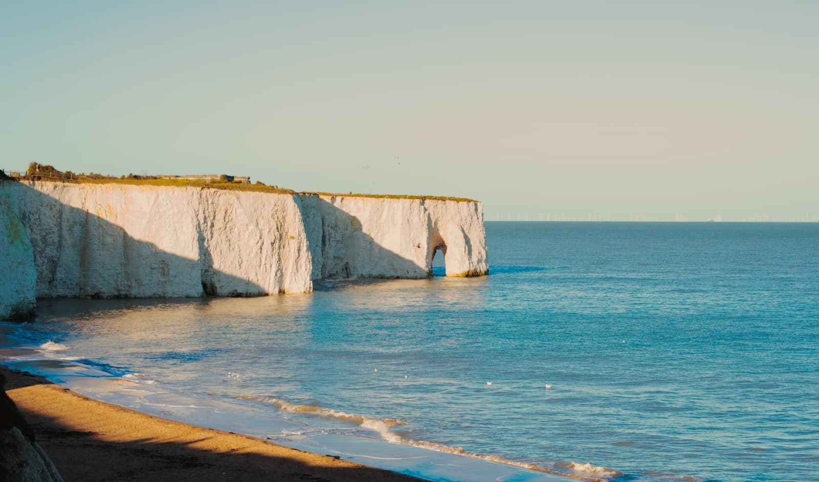 Margate — a view of a beach with a cliff in the background