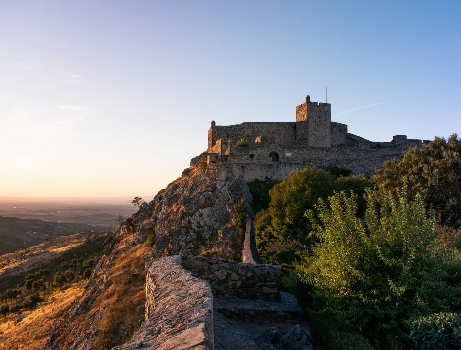 Marvão — a castle sitting on top of a hill next to a forest