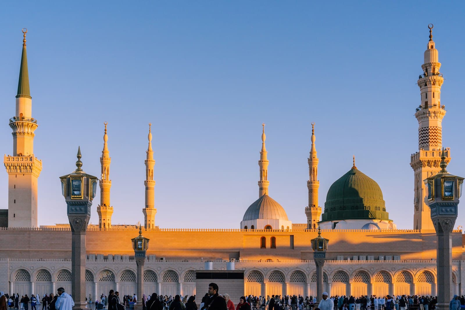 Medina — Masjid Al-Nabawi in Medina with minarets and domes under warm low sun light