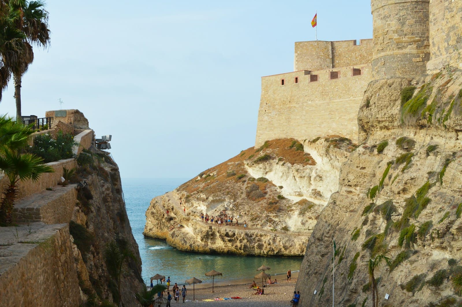 Melilla — people walking on brown concrete building near body of water during daytime