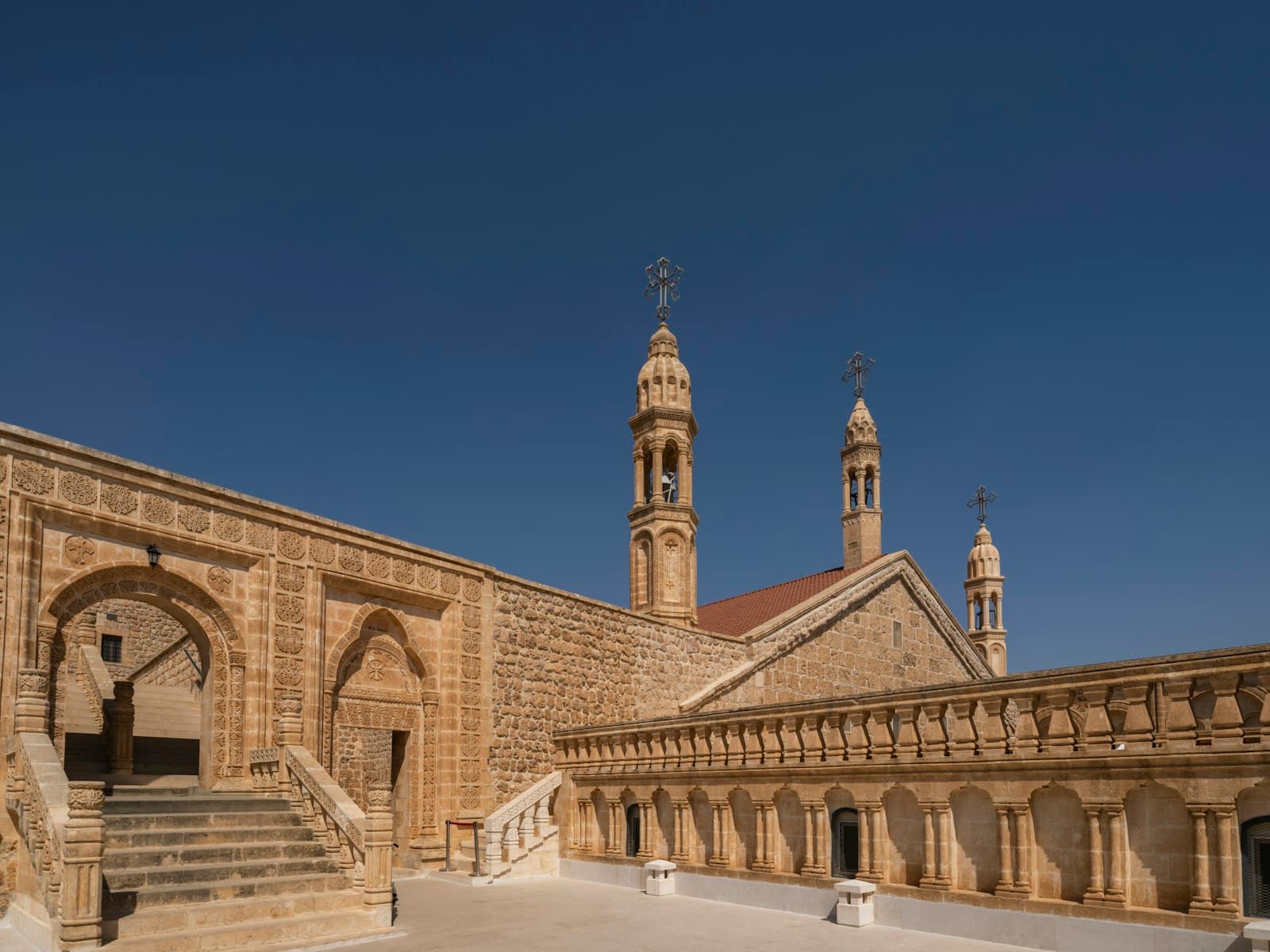 Midyat — a building with a clock tower and a staircase