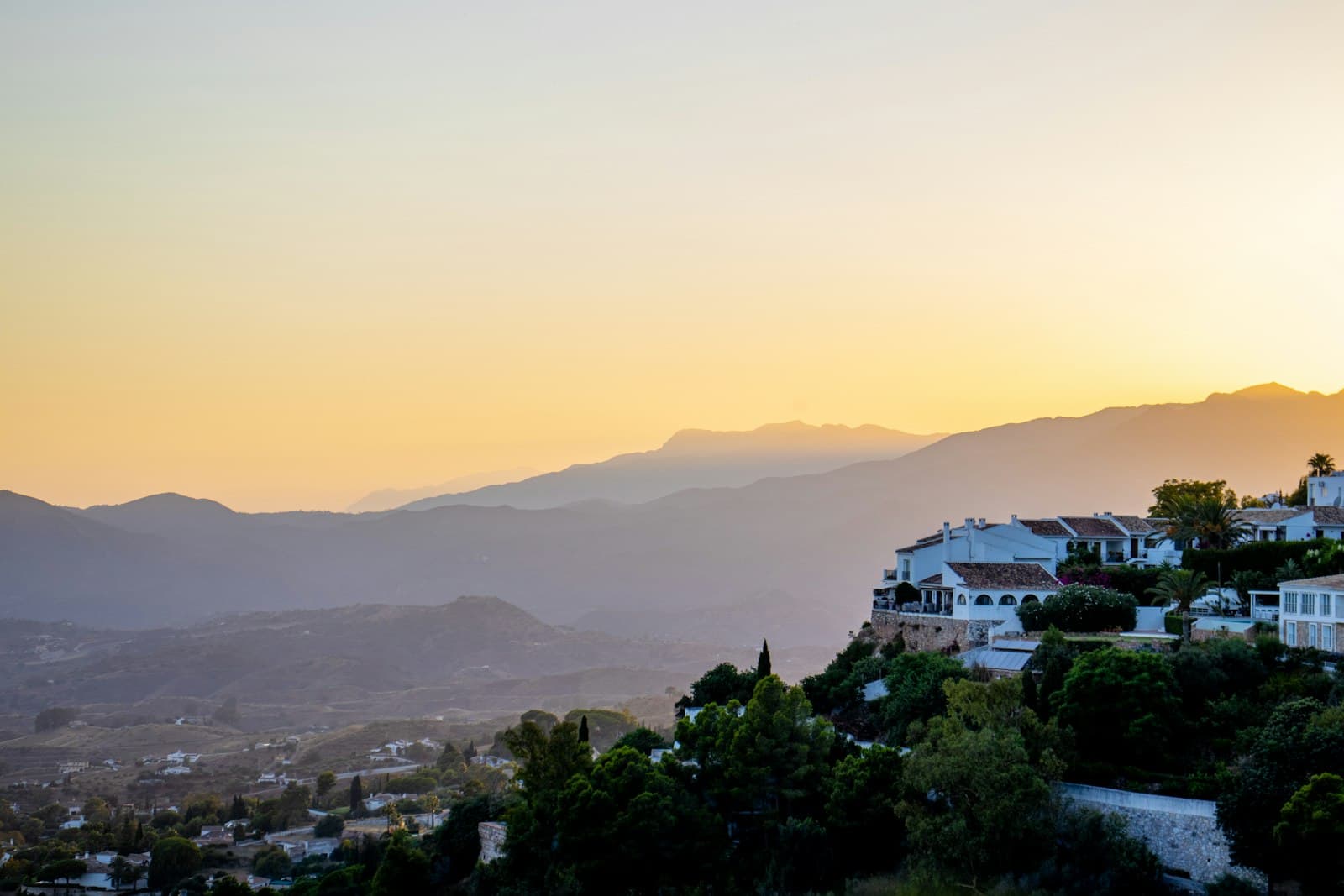 Mijas — a sunset view of a town with mountains in the background