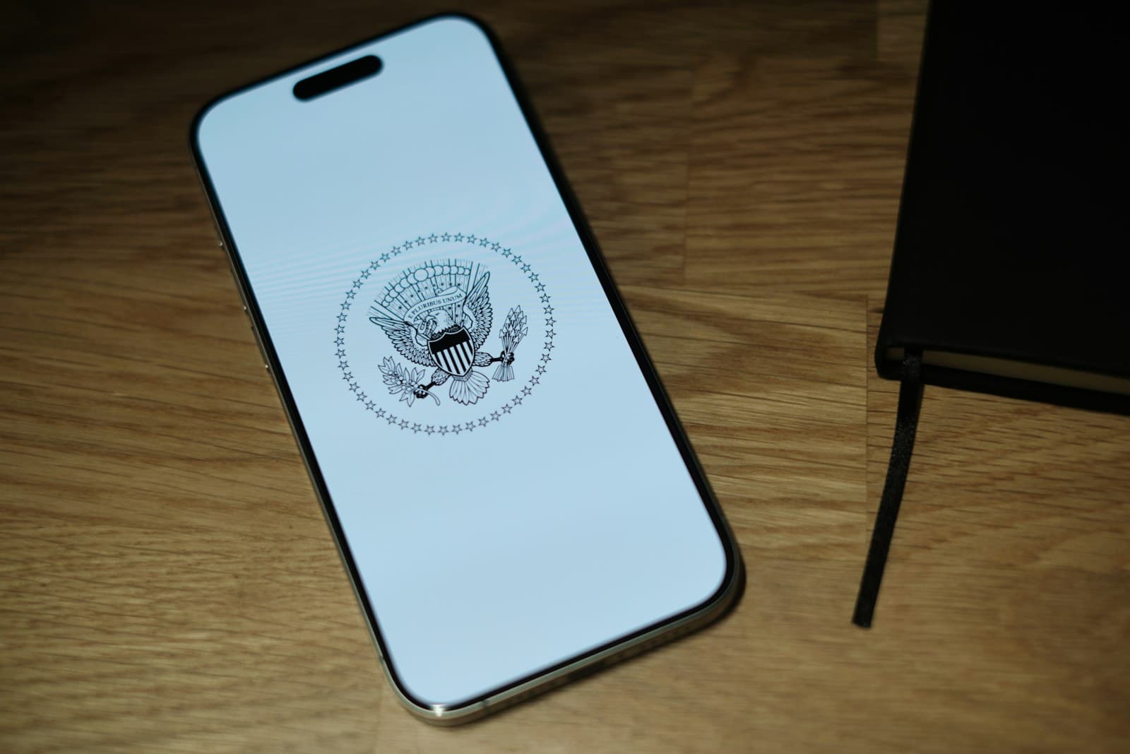 Mobile — A white iPhone sitting on top of a wooden table