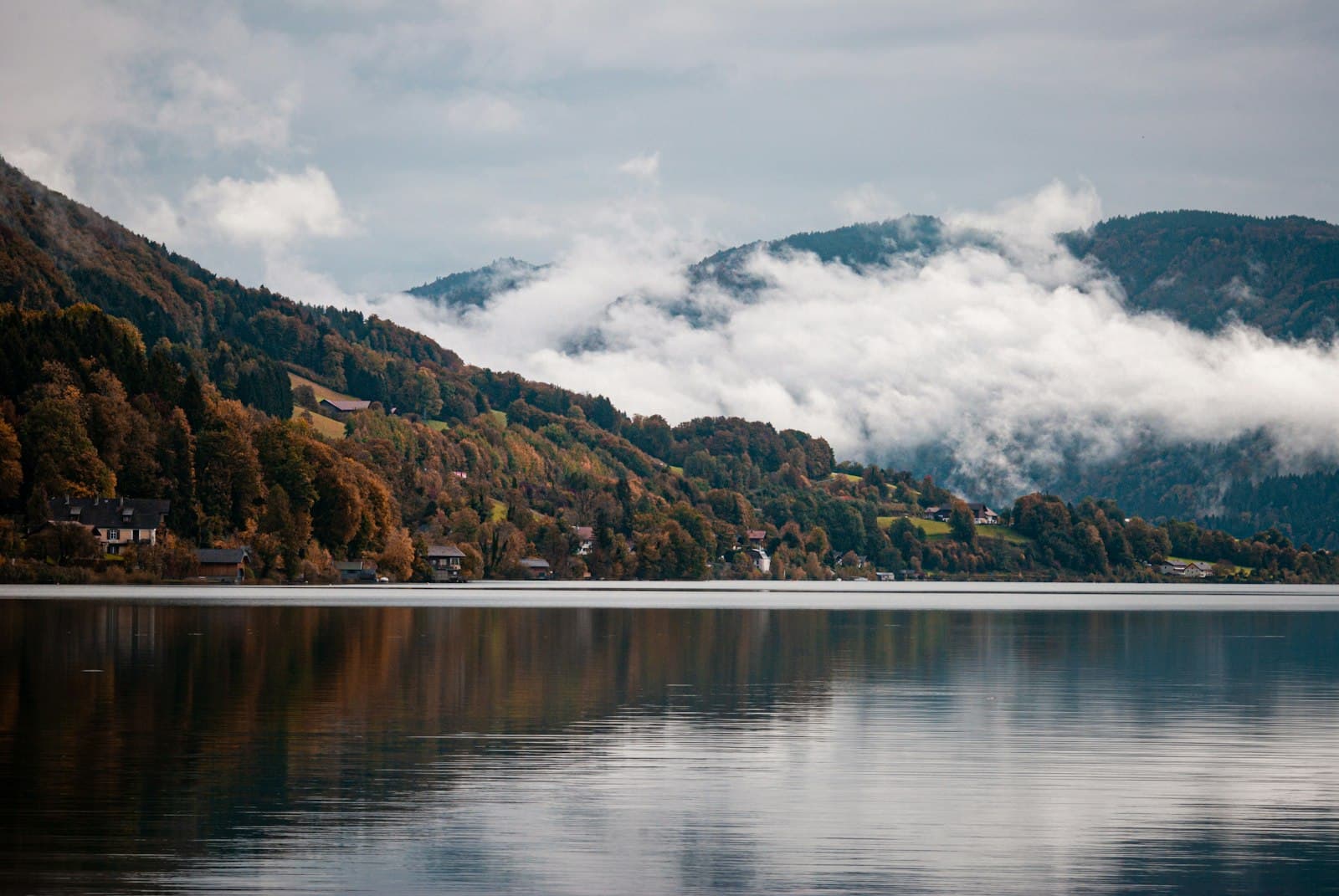 Mondsee — a body of water with trees and mountains in the background