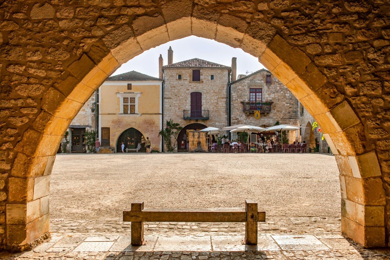 Monpazier — An arched opening frames a charming town square.