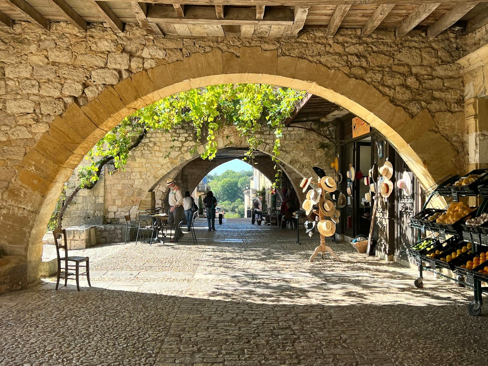 Monpazier — a cobblestone street with a stone archway