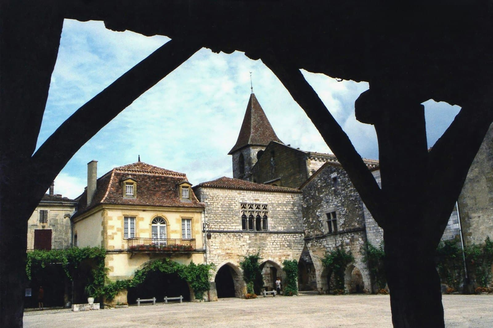Monpazier — Old european buildings framed by a wooden structure.