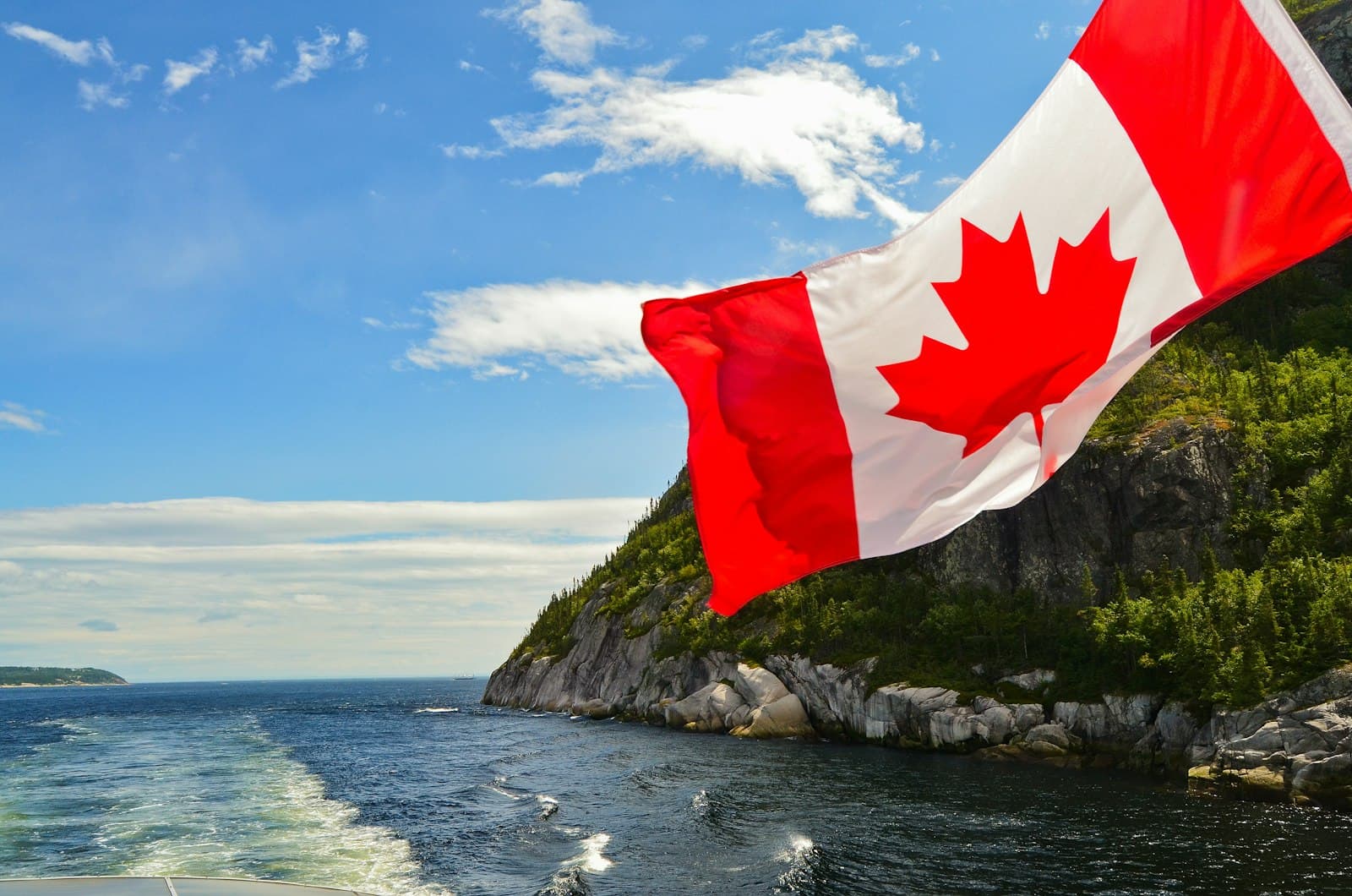 Mont-Tremblant — red and white flag on rock formation near body of water during daytime