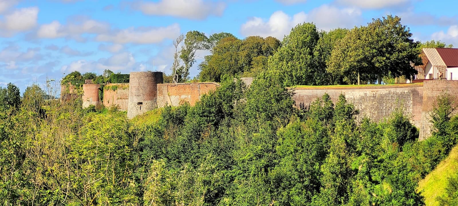 Montreuil-Bellay — green trees and brown brick building