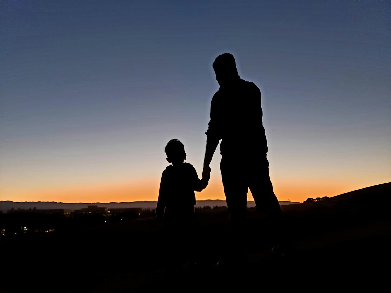 Mountain View — silhouette of man and woman standing on beach during sunset