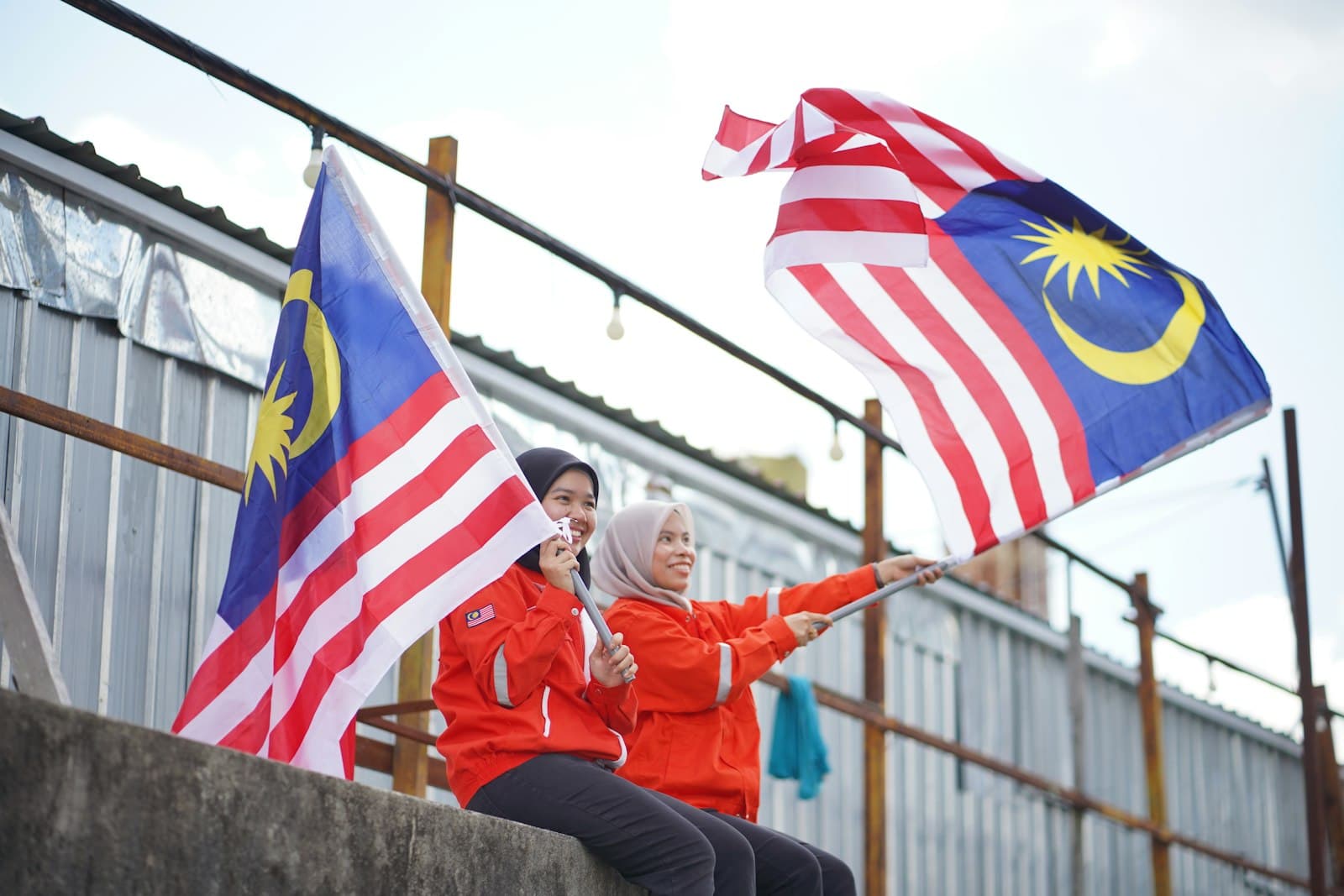 Mukah — two women holding malaysian and malaysian flags