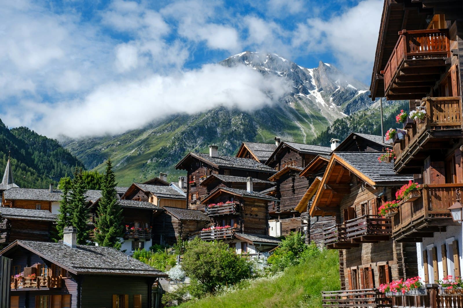 Mürren — brown wooden houses near green trees and mountain under white clouds during daytime