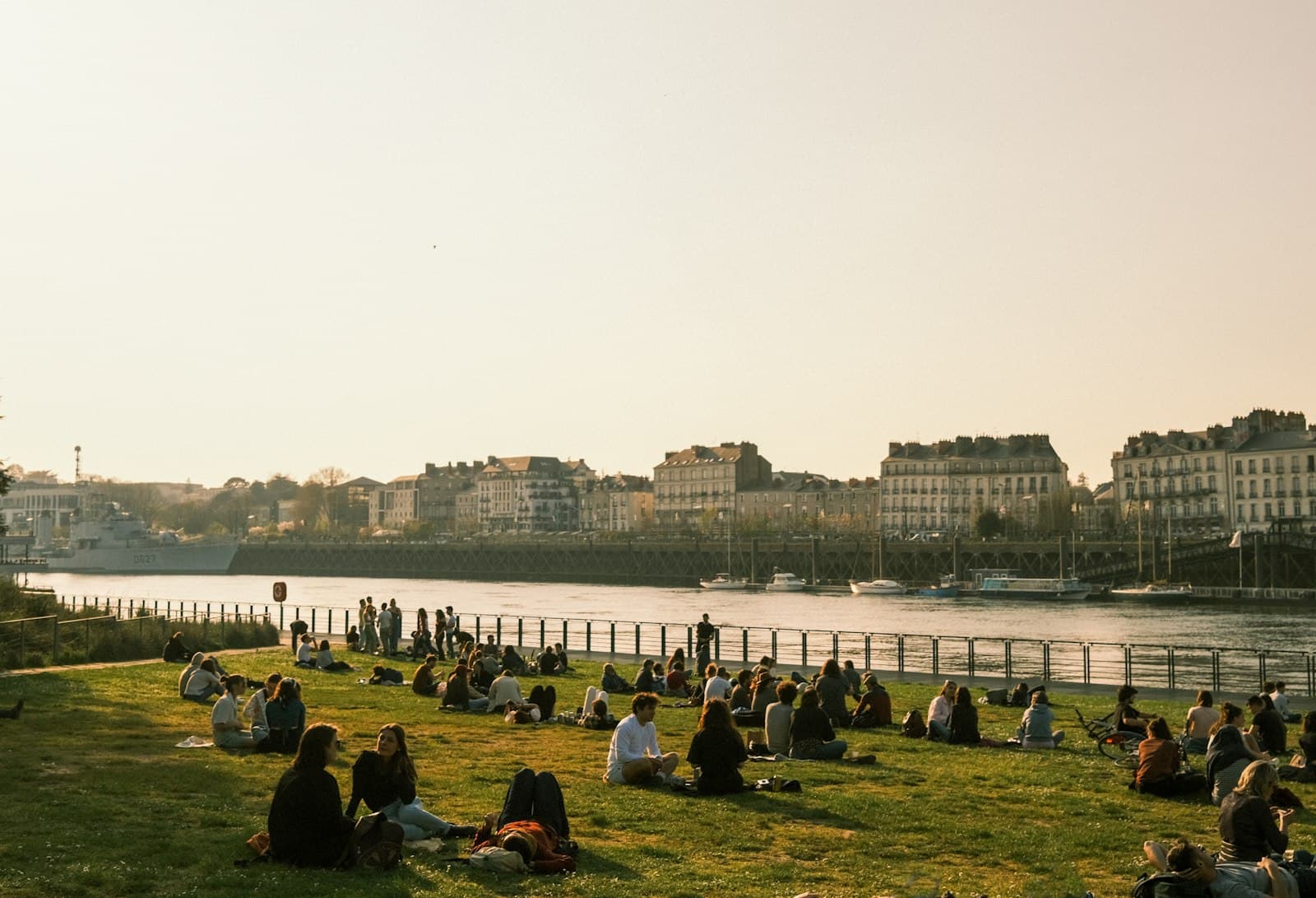 Nantes — a group of people sitting on top of a lush green field