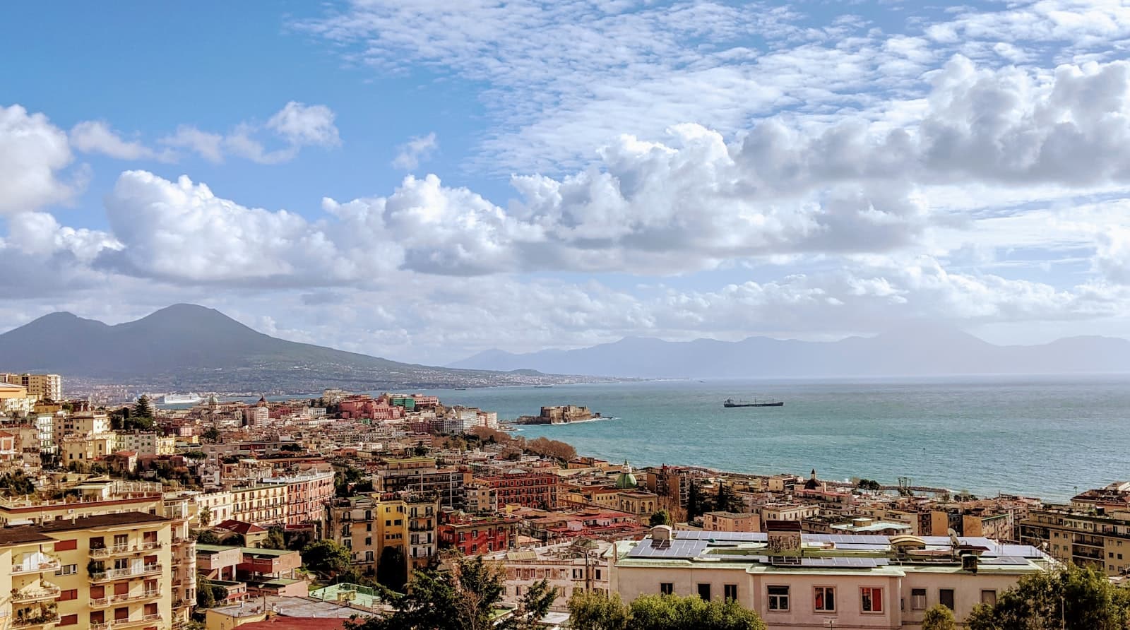 Naples — city buildings near sea under white clouds and blue sky during daytime