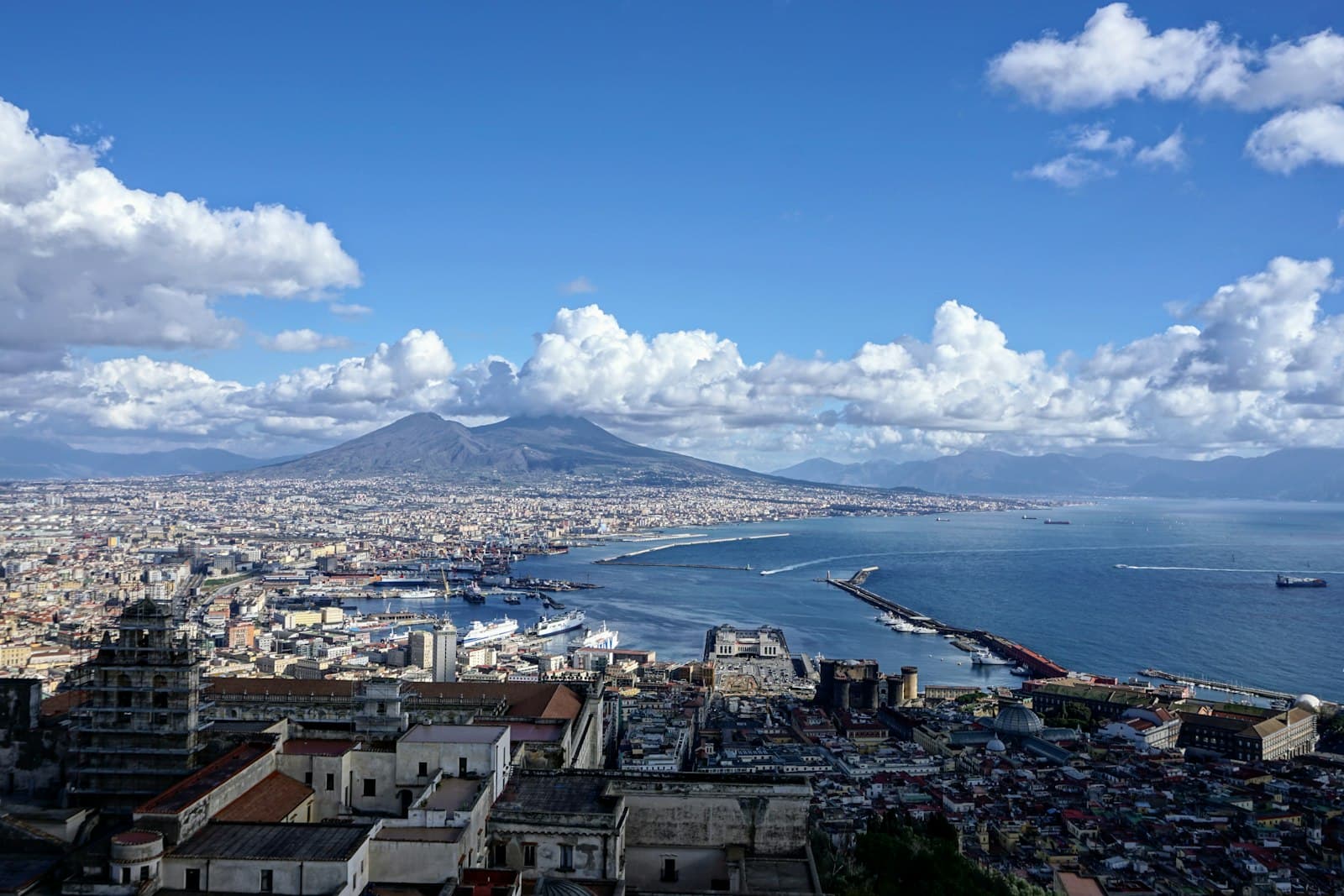 Naples — city buildings near body of water under blue and white cloudy sky during daytime