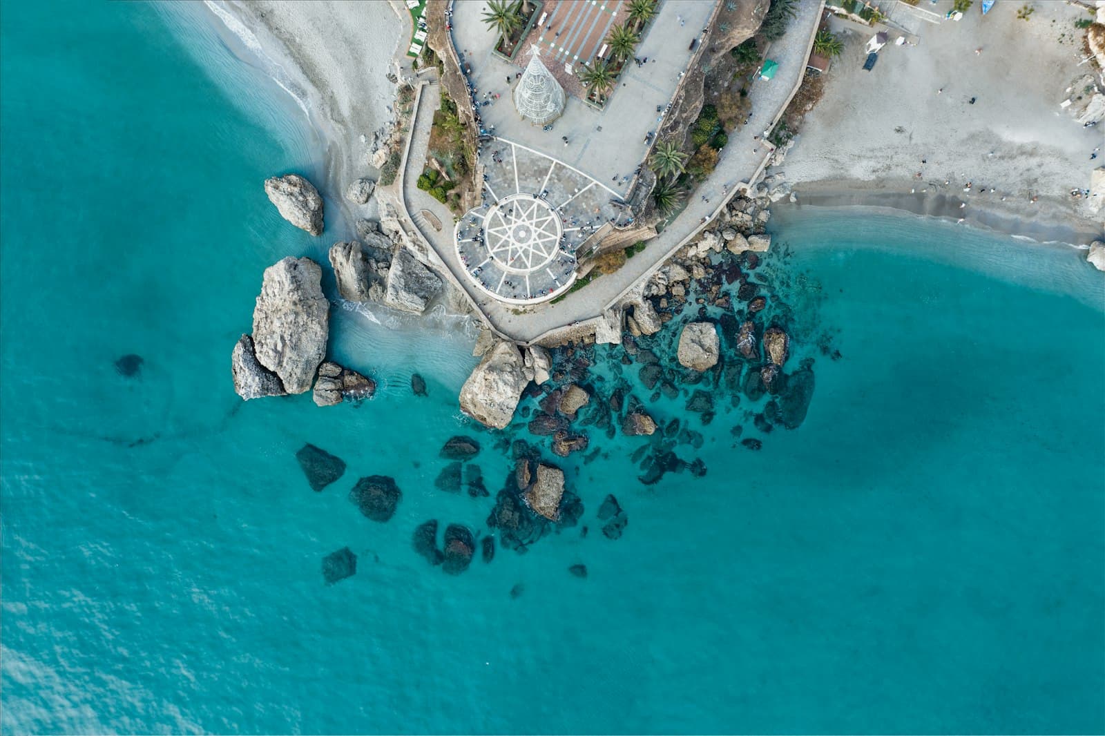 Nerja — an aerial view of a beach with rocks and a gazebo