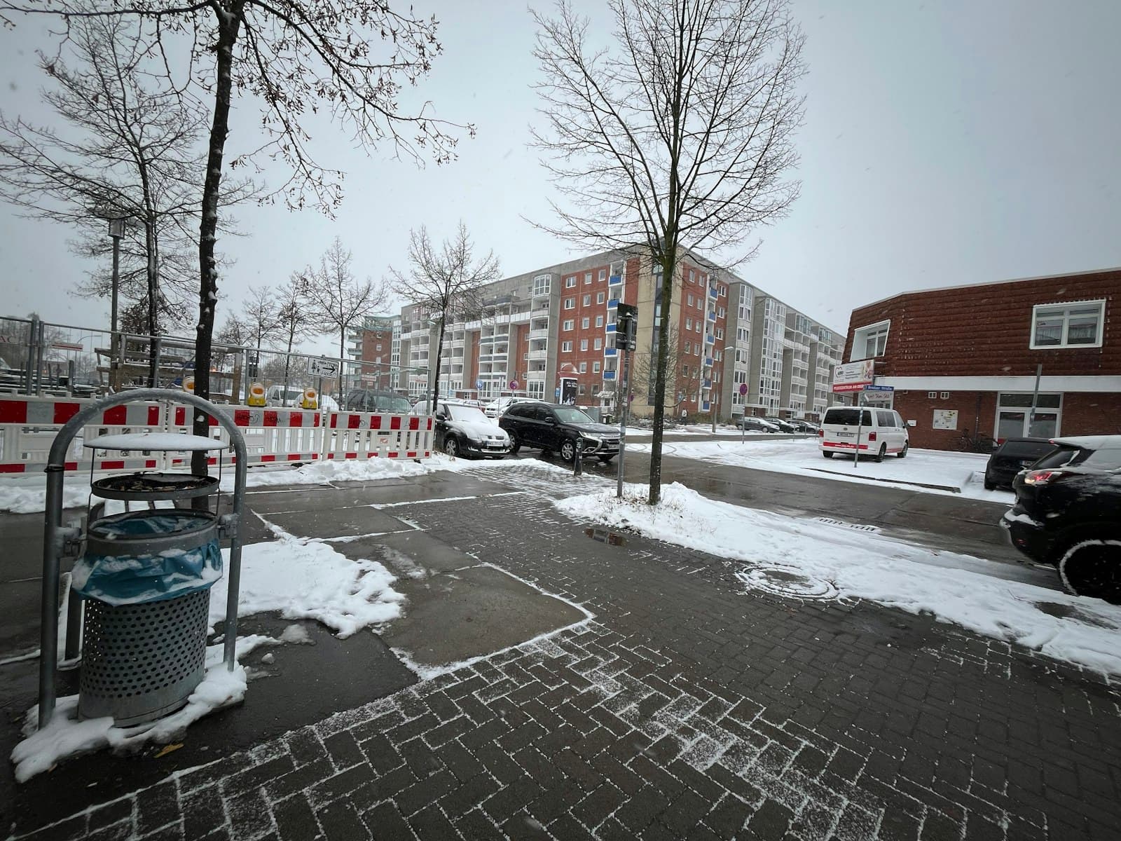 Neubrandenburg — a snowy street with cars parked on the side of the road