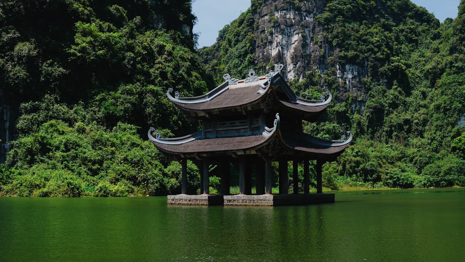 Ninh Bình — a pagoda in the middle of a lake surrounded by mountains