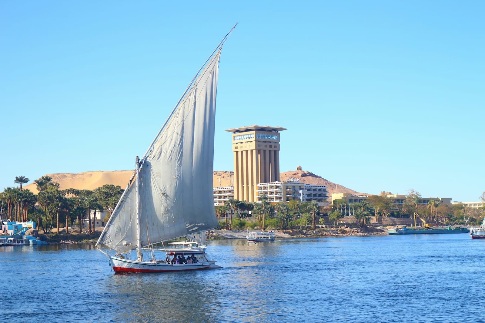Nuweiba — white sail boat on water near city buildings during daytime