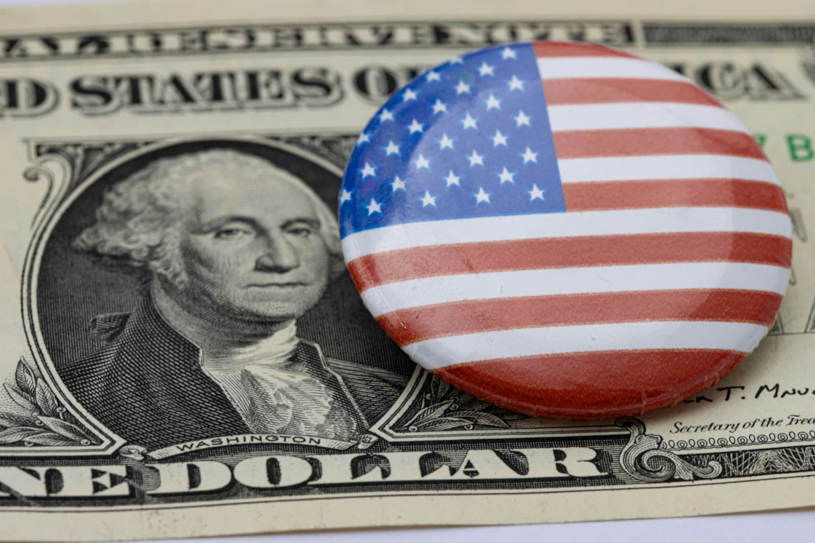 Ogunquit — a button with the american flag on it sitting on top of a hundred dollar bill