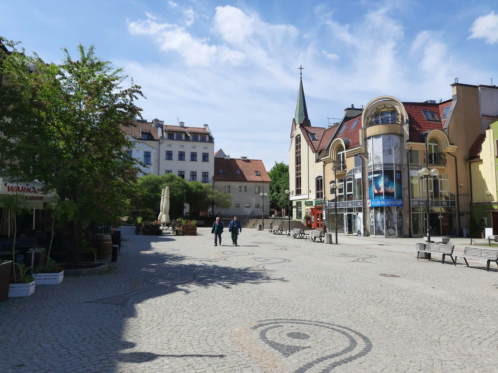 Olsztyn — a cobblestone street lined with buildings and trees