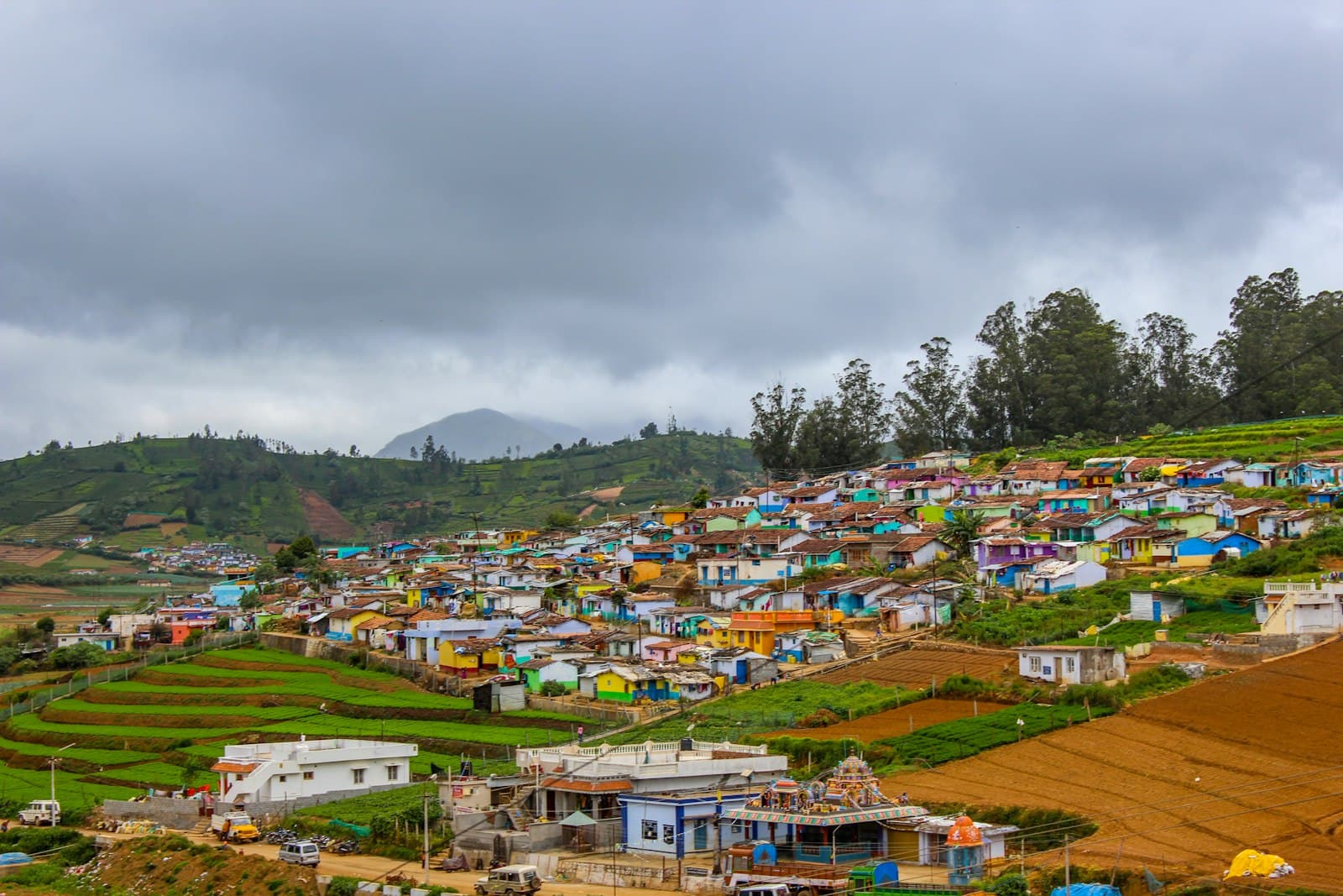 Ooty — houses near green trees under white clouds during daytime