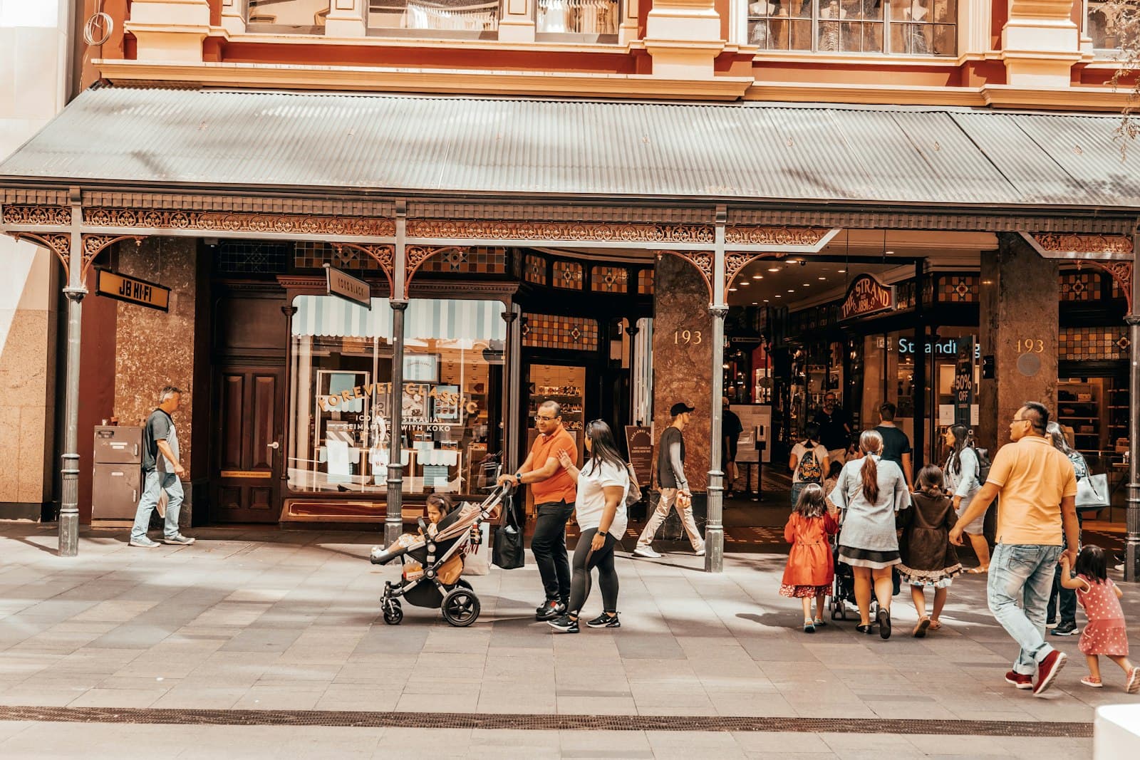 Orange — a group of people walking in front of a store