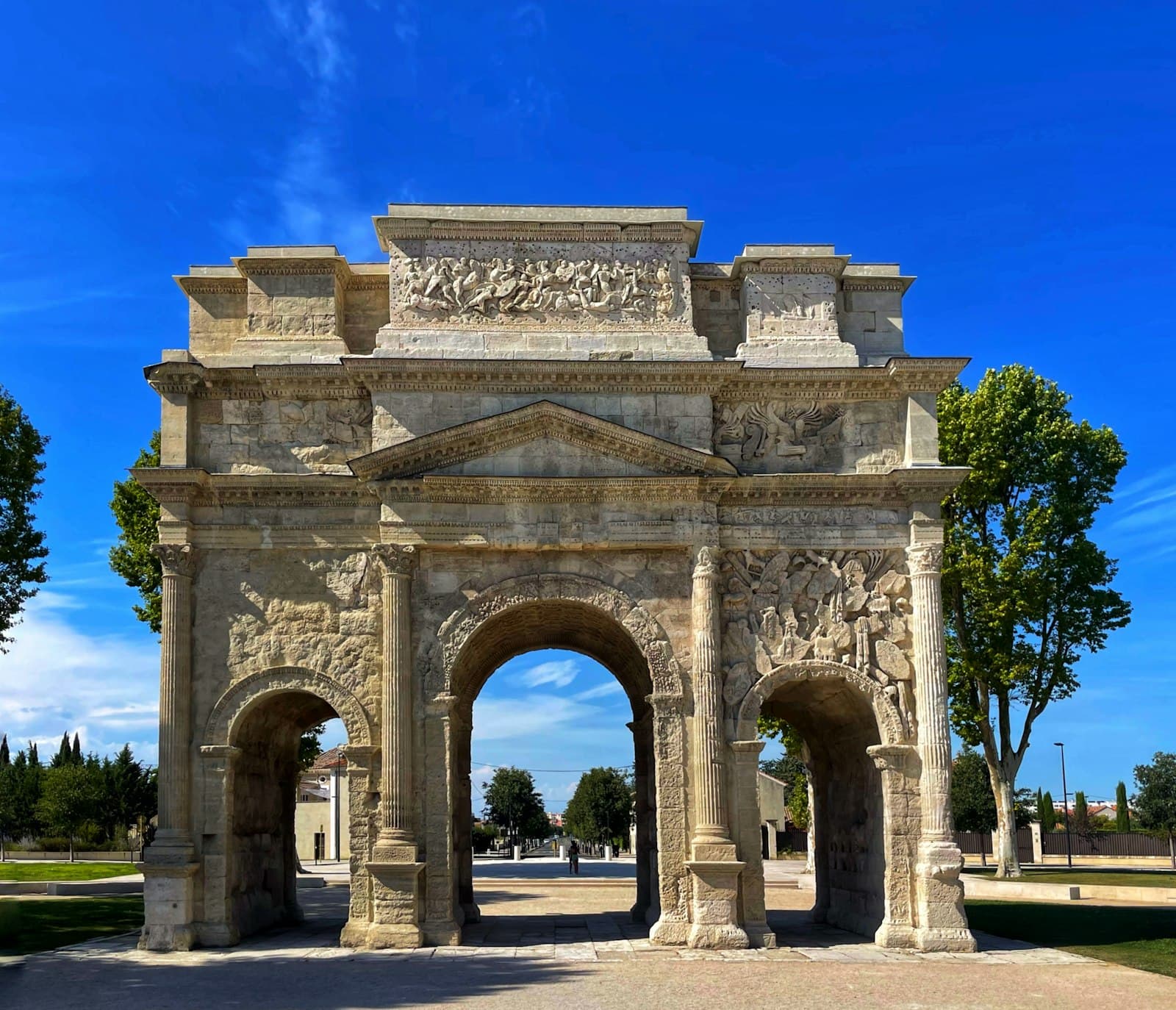 Orange — a stone archway with trees and blue sky