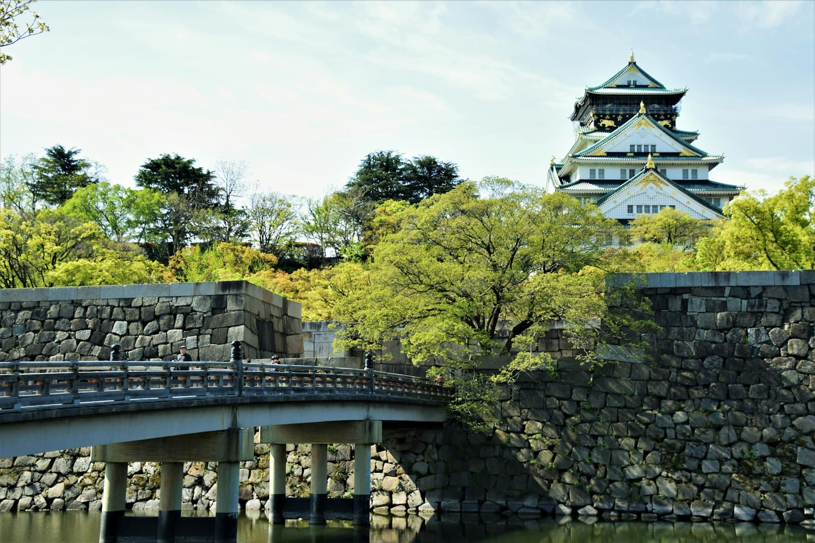 Osaka — white and black concrete building near green trees during daytime
