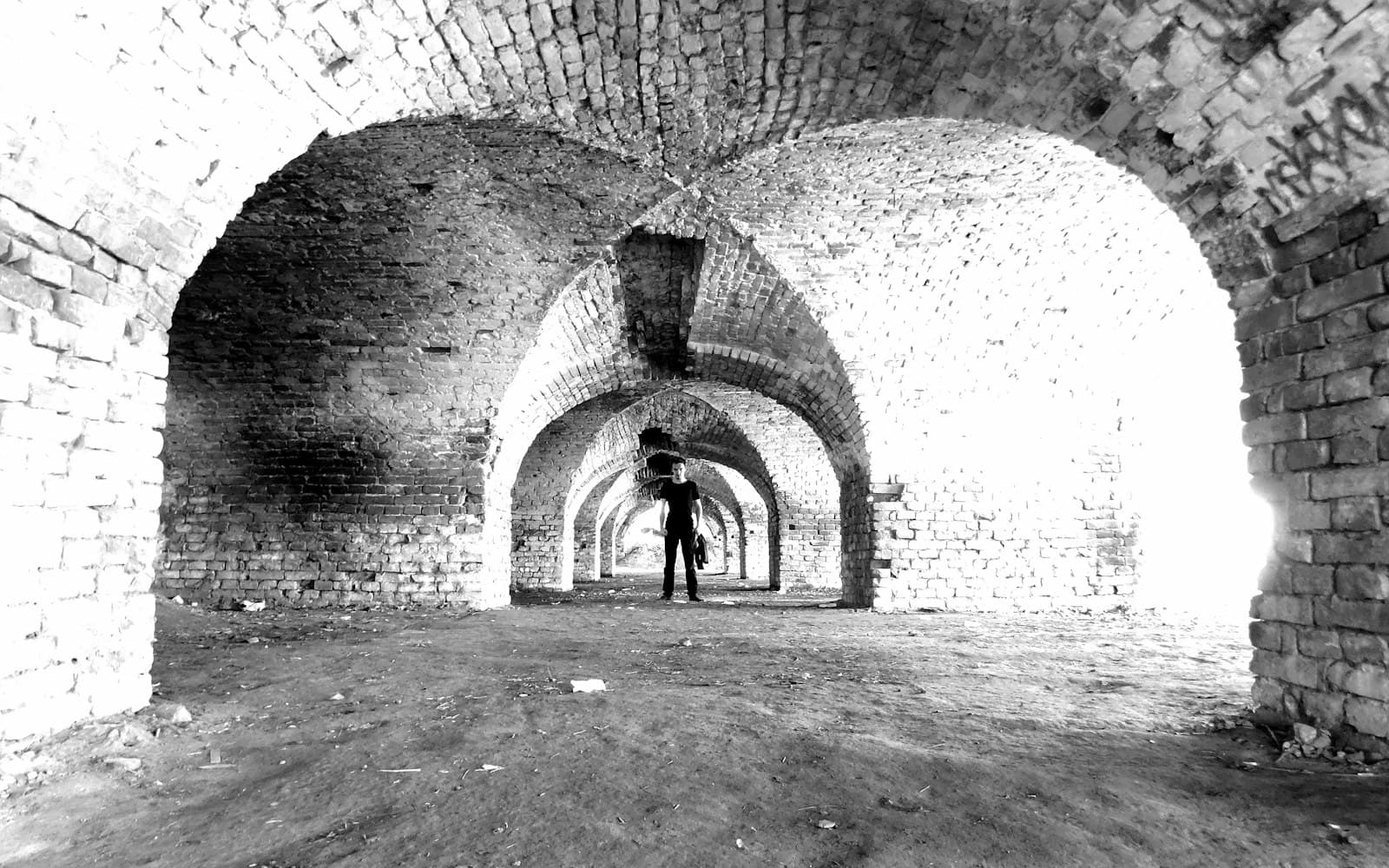 Osijek — grayscale photo of man walking on tunnel