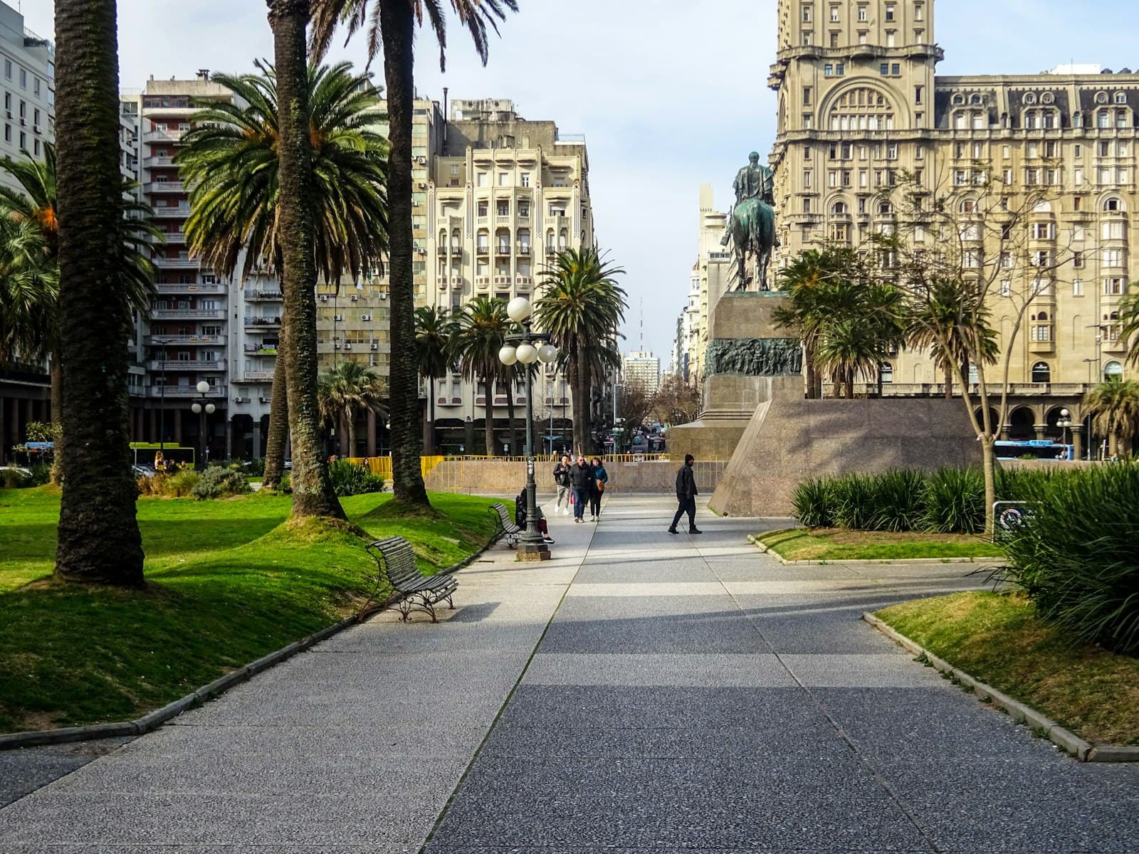 Paysandú — Pedestrian walkway in a city park with palm trees.