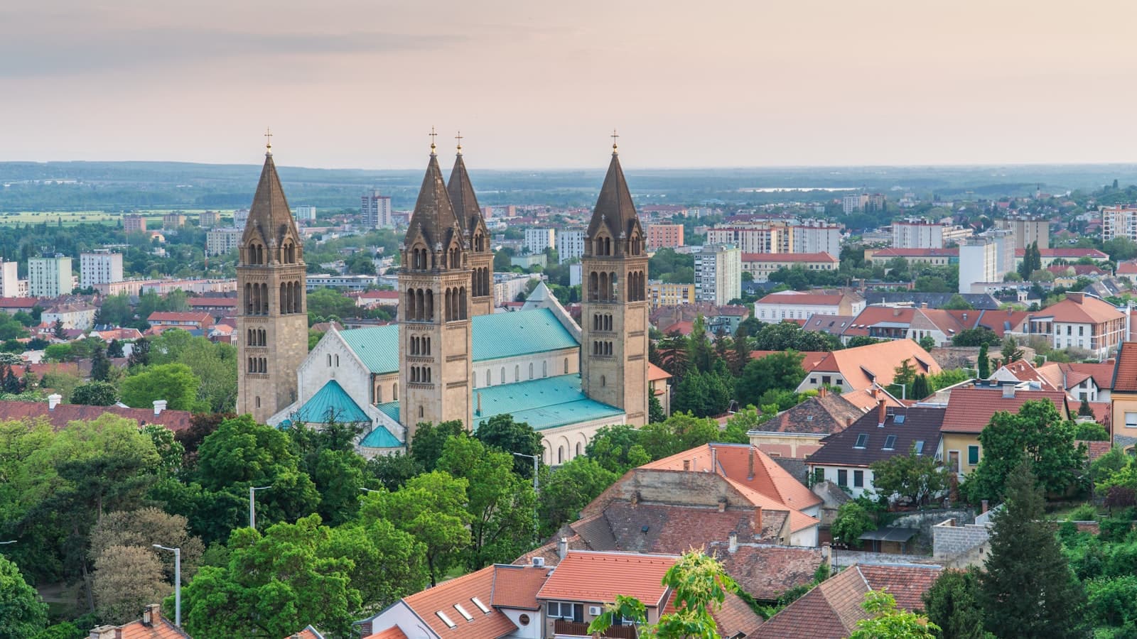 Pécs — a large building with towers surrounded by trees
