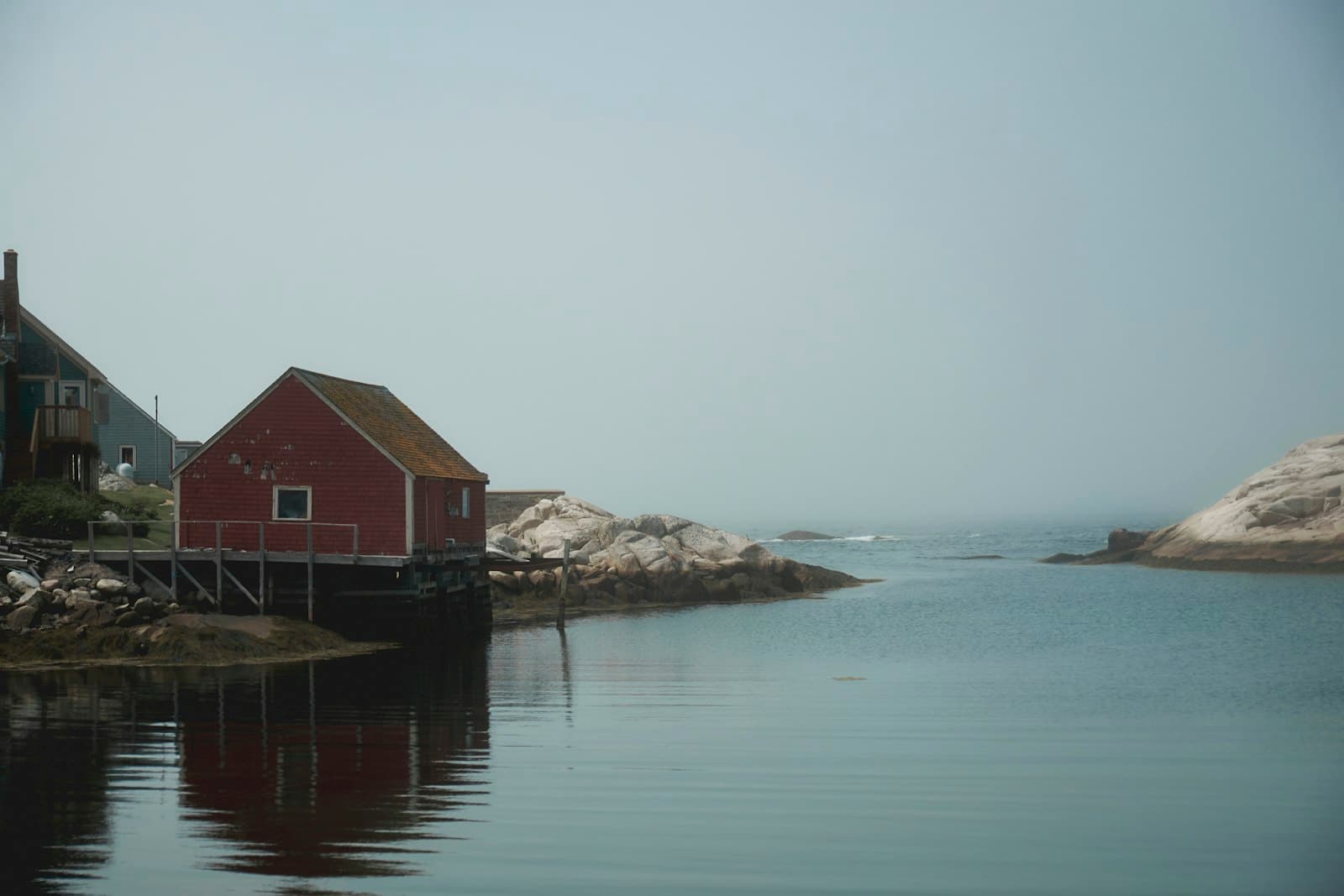 Peggy's Cove — a red house sitting next to a body of water