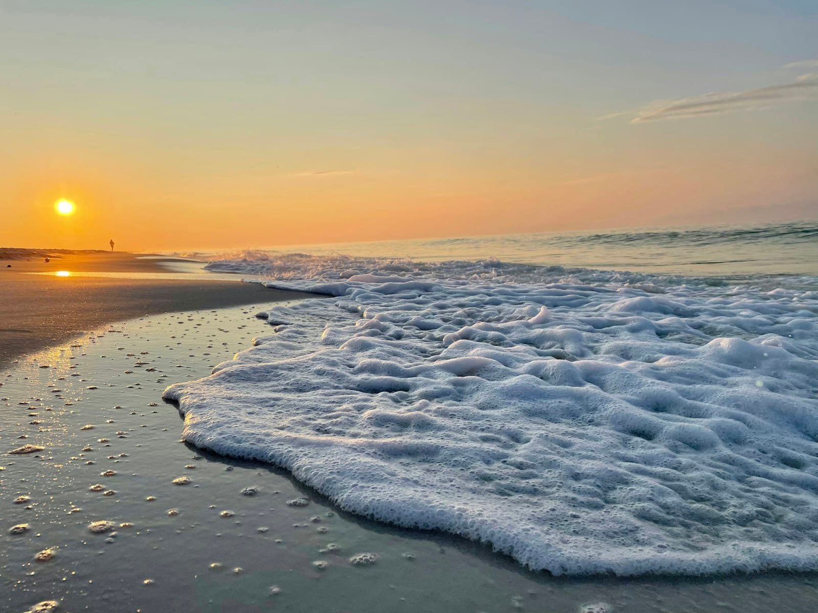 Pensacola — the sun is setting over the ocean with waves coming in