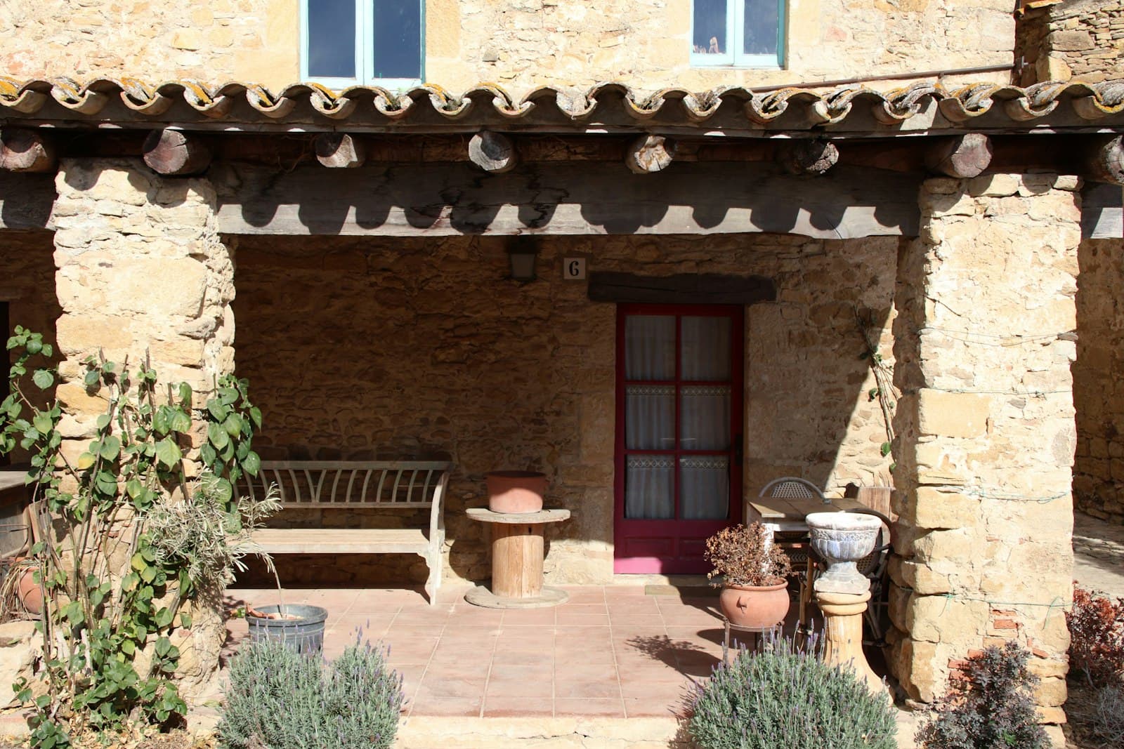 Peratallada — a patio with a bench and potted plants