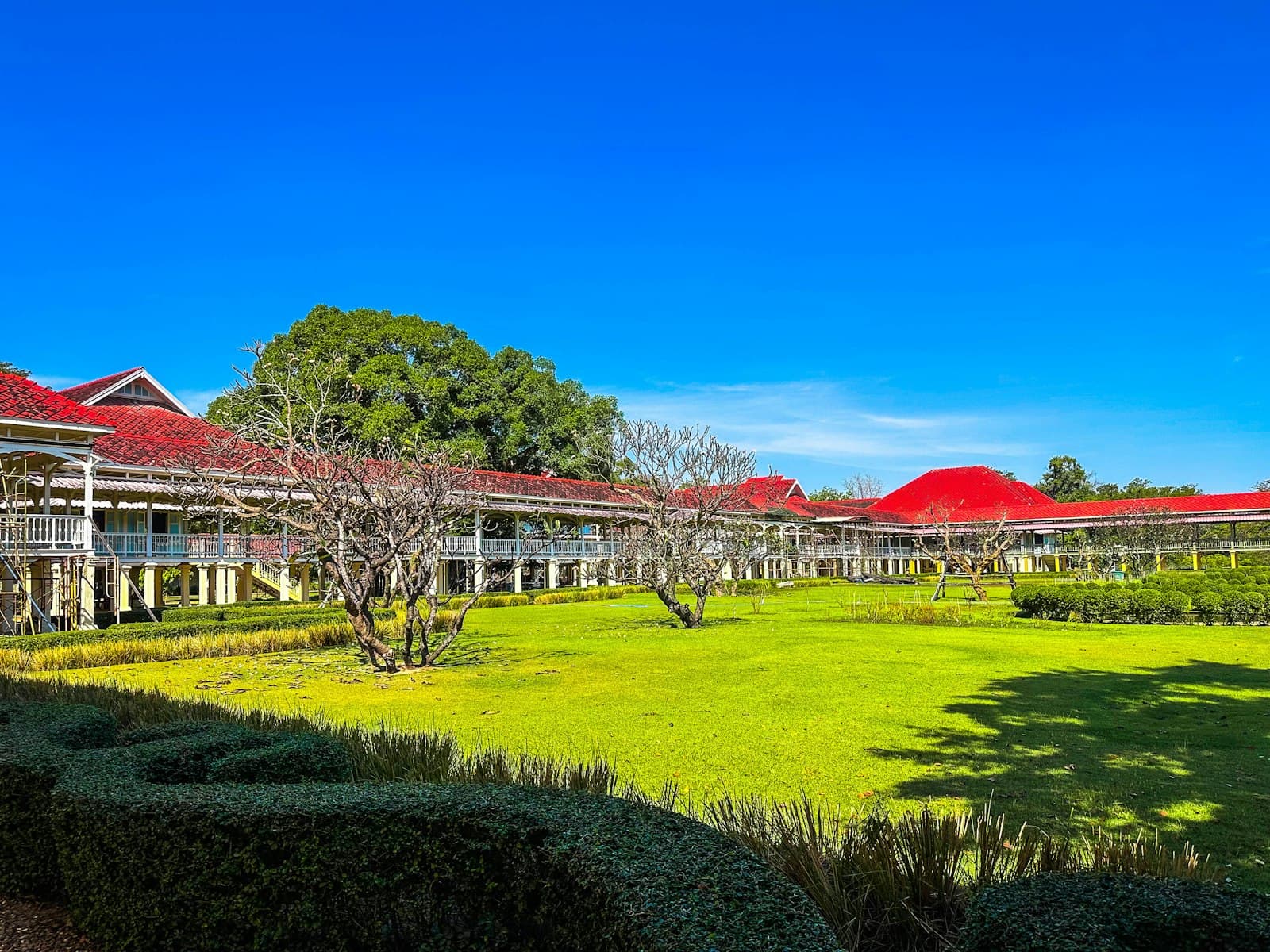 Phetchaburi — Long white building with red roofs and green lawn.