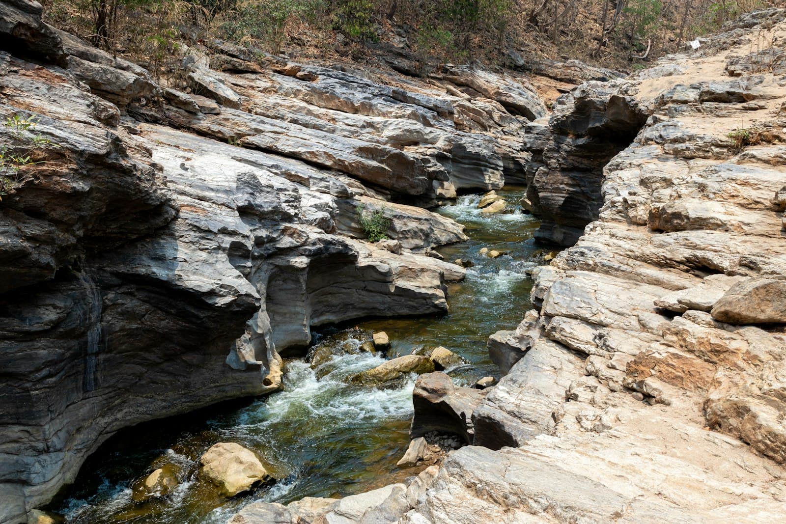 Phrae — a river running through a rocky canyon next to a forest
